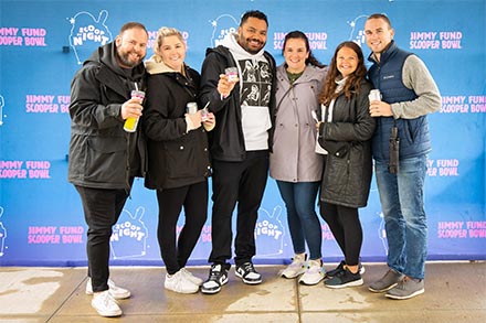 A group of people pose for a photo at Scoop at Night